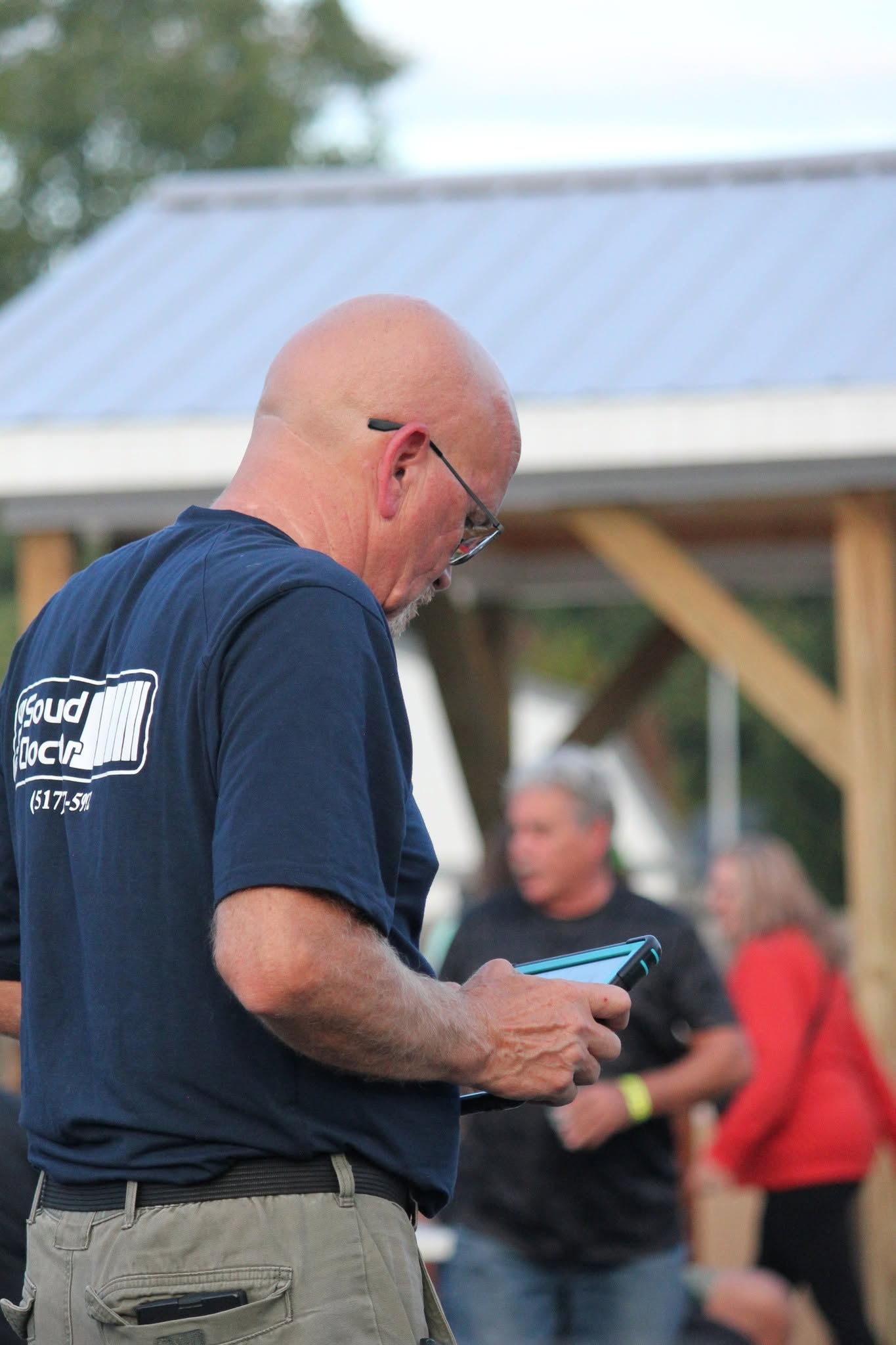 Sound engineer with tablet at outdoor pavilion